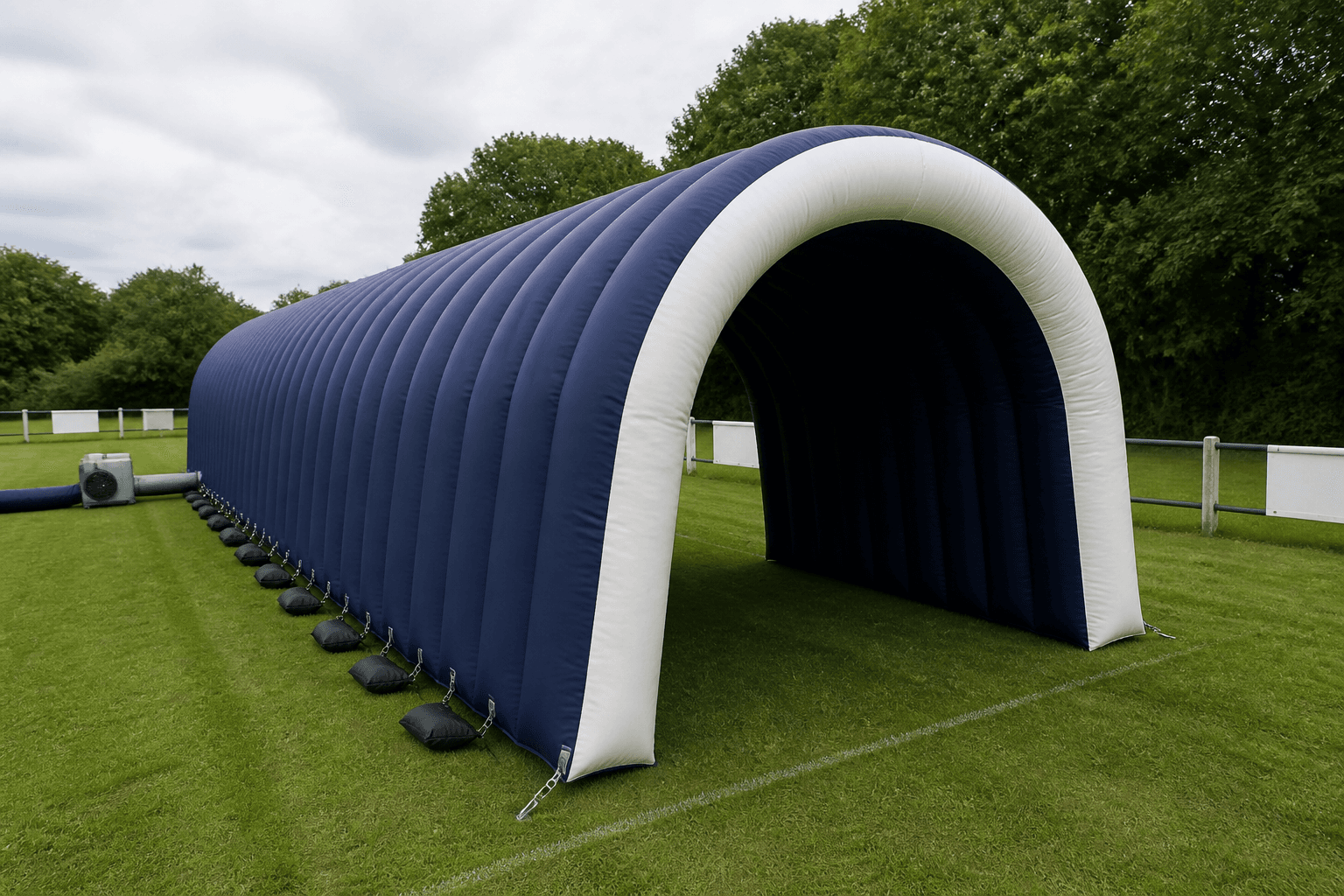Long deep navy inflatable entrance tunnel with an off-white arched opening on grass