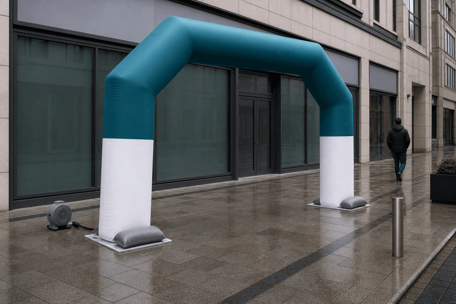 Deep teal and white inflatable entrance arch with sandbagged feet outside a glazed storefront