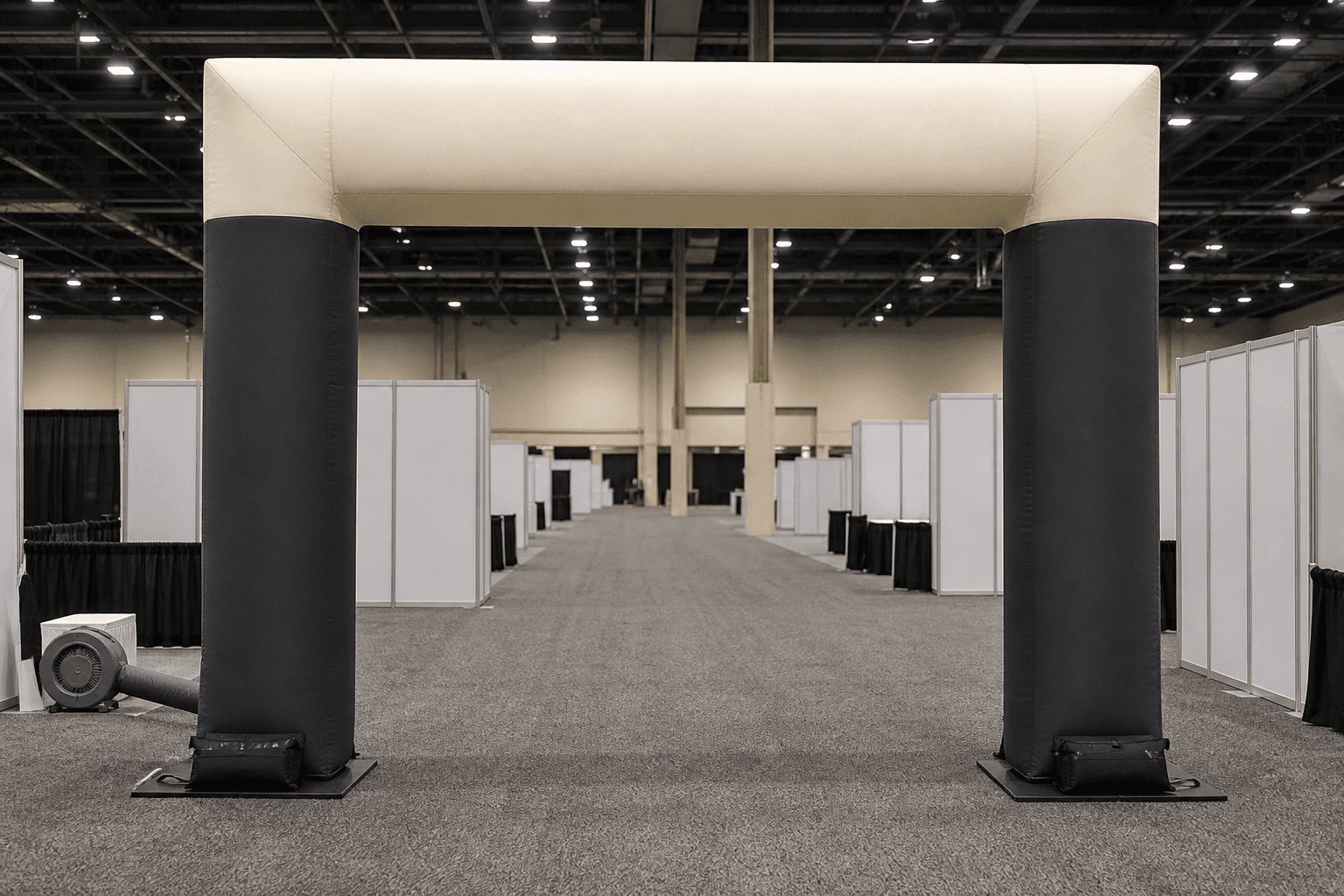 Charcoal and cream square-profile inflatable gateway in an exhibition hall aisle