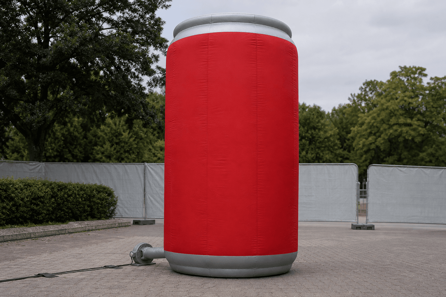 Crimson inflatable drinks can replica with silver-grey bands at an outdoor event area