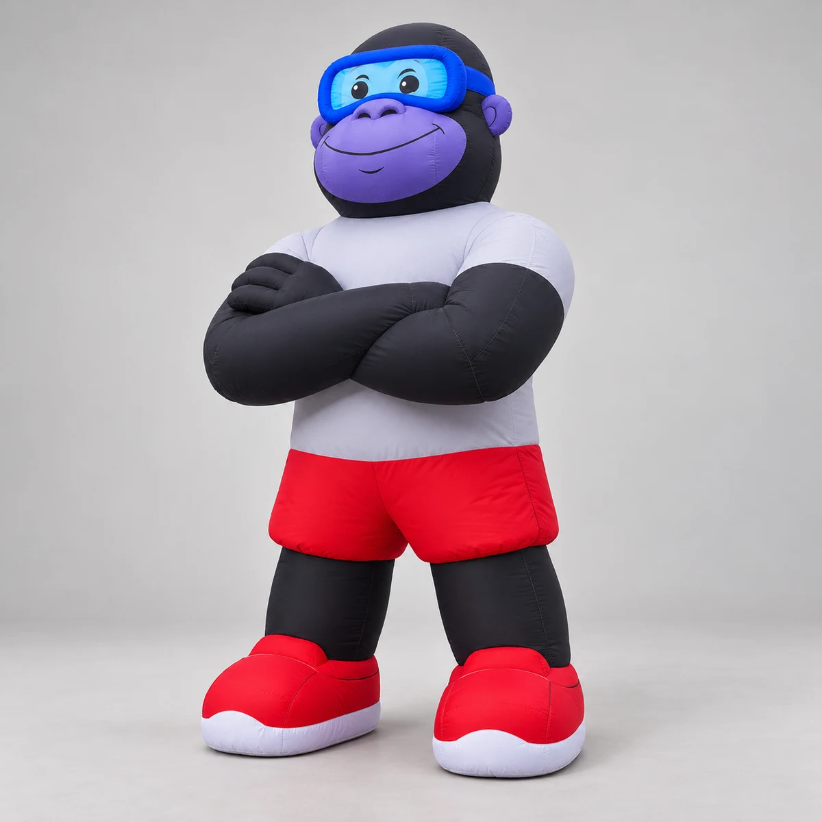Three-quarter concept view of crossed-arm gorilla mascot with blue goggles and red-and-white sneakers